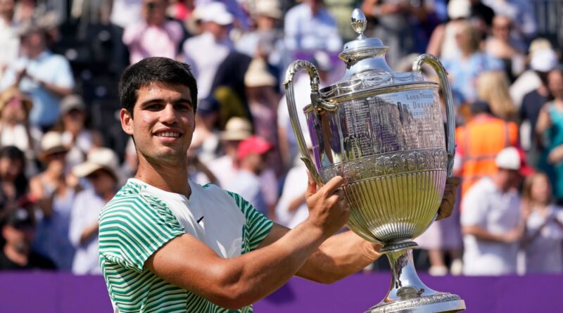 Carlos Alcaraz, of Spain, holds the trophy after defeating Alex de Minaur, of Australia, 6/4, 6/4 in the mens singles final match at the Queens Club tennis tournament in London, Sunday, June 25, 2023. (AP Photo/Alberto Pezzali)